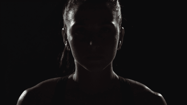 Dramatic lighting of female athlete representing practice of mental skills