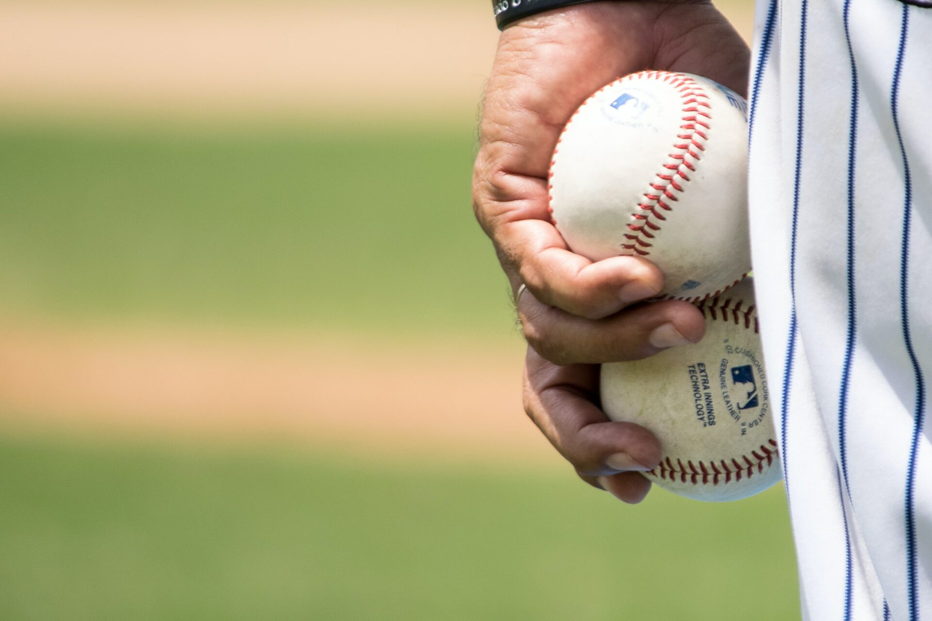 A baseball player holds two balls pausing a moment to visualize his pitch